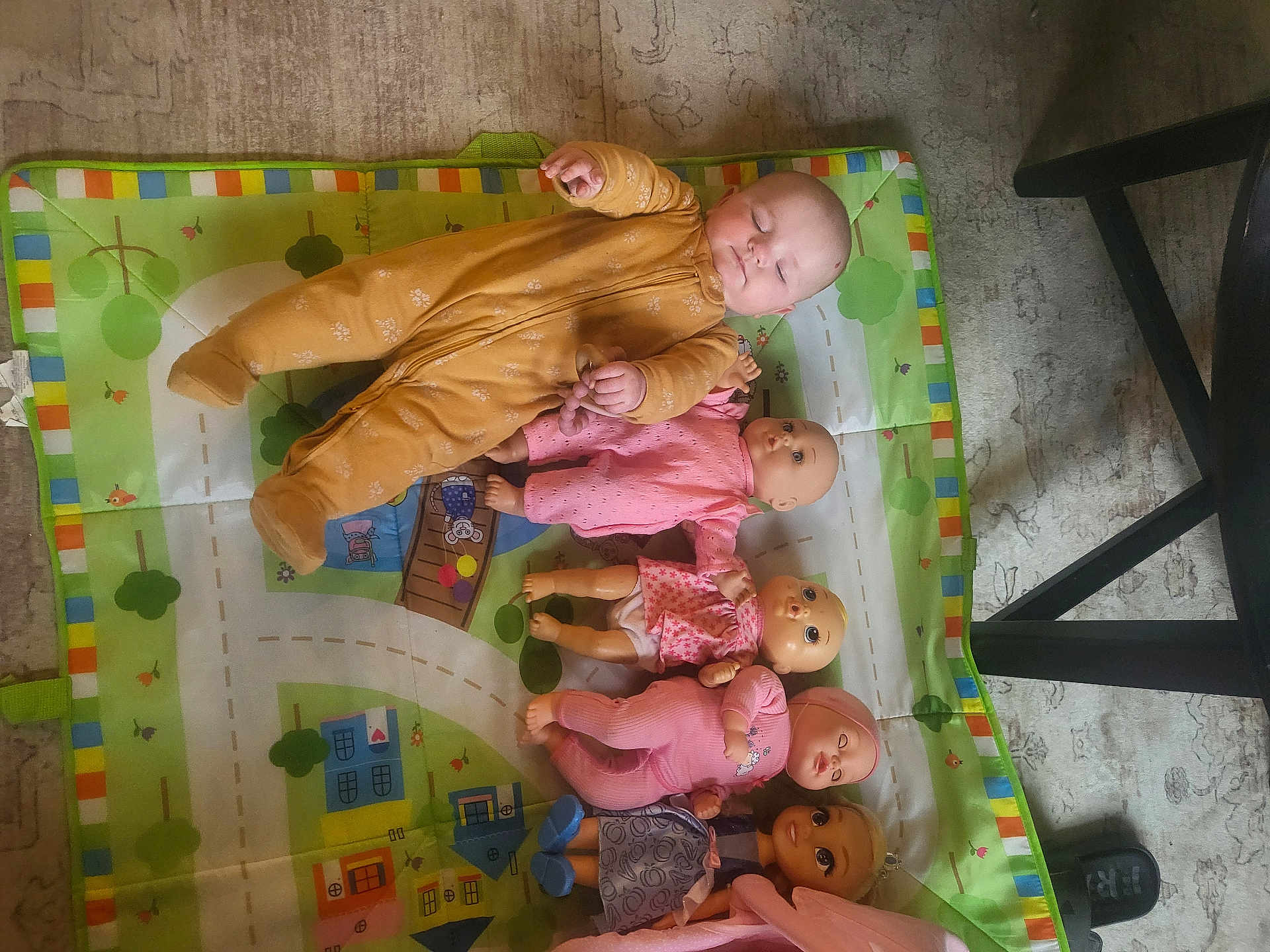 Piper is registered to the contest to win money with this photo: baby, doll, play_mat, child, sleeping, toy, floor, onesie, pink, purple, mustard, indoor, carpet, furniture_leg, footwear, cute, infant, pose, relaxing, collection