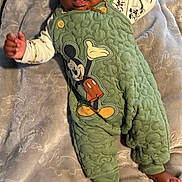 Milo joined the competition — help win amazing prizes! baby, infant, child, mickey_mouse, green_overall, blanket, soft_texture, cute, lying_down, playful, clothing, foot, hand, portrait, indoors, smiling, head, face, happy, comfortable