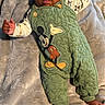 baby, infant, child, mickey_mouse, green_overall, blanket, soft_texture, cute, lying_down, playful, clothing, foot, hand, portrait, indoors, smiling, head, face, happy, comfortable