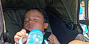 Kai is registered to the contest to win money with this photo: toddler, sleeping, stroller, child, baby, sippy_cup, outdoor, sunlight, foot, hand, seatbelt, canopy, summer, relaxation, nap, skin, toy, infant, daytime, shade