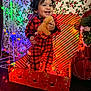 celebration, child, christmas, christmas_lights, curly_hair, decorations, festive, gift_box, gingerbread_man, happy, holiday_decor, holly_wallpaper, indoors, joy, person, plush_toy, red_pajamas, smiling, striped_wrapping_paper, toddler