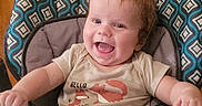 Ronin joined the competition — help win amazing prizes! activity_seat, baby, brown_hair, child, clothing, face, happy, highchair, home, indoor, infant, laughing, pacifier, patterned_chair, photography, portrait, seated, shirt, smiling, tray