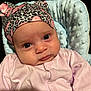 baby, infant, face, hat, pink_clothing, blanket, patterned_hat, leopard_print, butterfly, close_up, portrait, child, cute, soft_texture, newborn, pajamas, resting, indoors, comfort, expression
