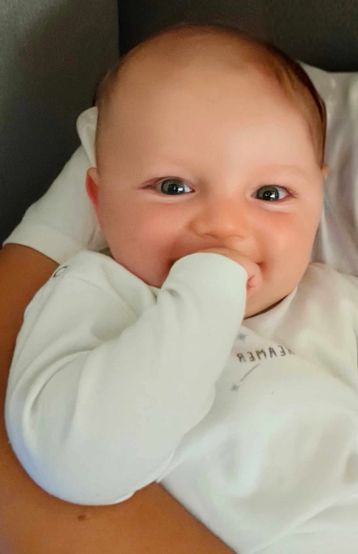 Hayden a rejoint le concours — aidez-le/la à gagner de superbes lots ! baby, infant, smiling, hand_in_mouth, white_clothing, close_up, portrait, child, cute, happy, person, skin, face, eyes, mouth, arm, holding, cozy, warm, soft_light