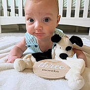 Wesley joined the competition — help win amazing prizes! baby, infant, three_months, plush_toy, dog_toy, blanket, crib, nursery, child, portrait, cute, smiling, lying_down, indoor, person, young_child, soft, wooden_sign, clothing, blue_outfit
