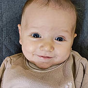 Léandre participe au concours pour gagner de l'argent avec cette photo : baby, infant, smile, blue_eyes, chubby_cheeks, portrait, close_up, sweater, beige_clothing, blanket, cushion, indoors, head, face, skin, gaze, happy, person, cute, babywear