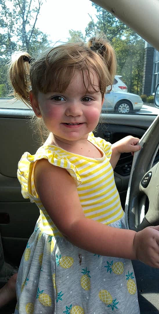 Harmony is registered to the contest to win money with this photo: auto_part, blond, car, car_seat, child, ear, finger, hair, hairstyle, hand, joy, long_hair, person, smile, thumb, toddler, vehicle, vehicle_door