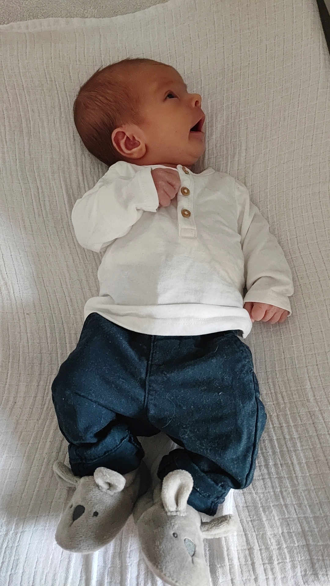 élyor a rejoint le concours — aidez-le/la à gagner de superbes lots ! baby, infant, blanket, white_shirt, dark_pants, slippers, mouse_slippers, footwear, lying_down, cute, indoors, child, newborn, soft_texture, cozy, small_hands, small_feet, portrait, side_view, comfortable