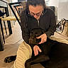 Astro a rejoint le concours — aidez-le/la à gagner de superbes lots ! person, dog, labrador, indoor, floor, cuddling, glasses, sweater, brown_dog, home, cozy, affection, pet, companion, relaxation, kitchen, furniture, human_animal_interaction, casual, comfort