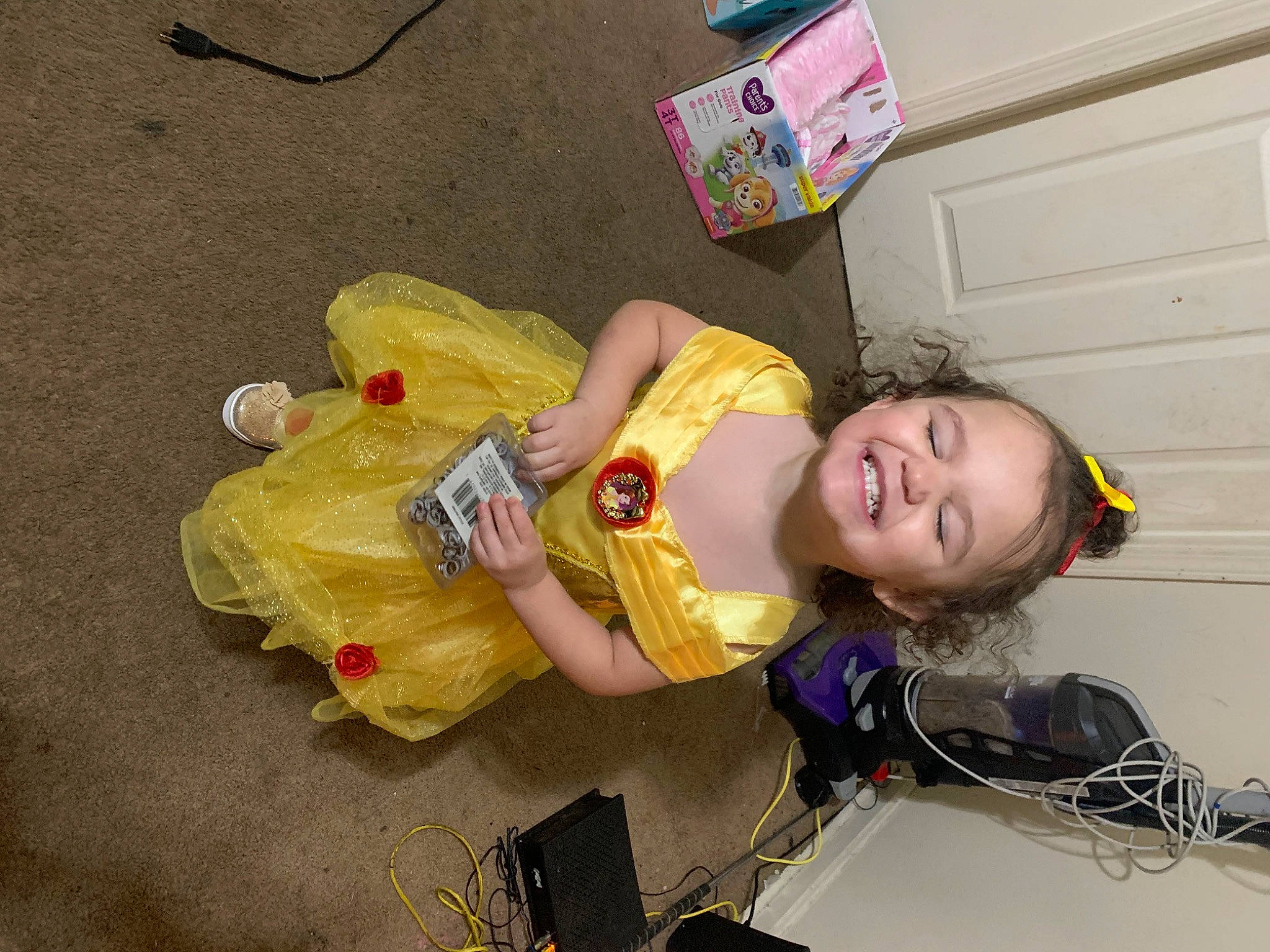 Norah is registered to the contest to win money with this photo: child, costume, flooring, fun, happy, joy, person, play, smile, toddler