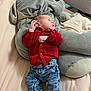 baby, infant, plush_toy, elephant, bed, red_shirt, denim_pants, socks, sleepwear, soft_toy, child, cute, resting, indoors, portrait, cozy, fabric, comfort, small_person, laying_down
