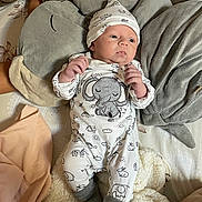 Kenzo participe au concours pour gagner de l'argent avec cette photo : baby, infant, elephant, plush_pillow, bed, blanket, hat, onesie, gray_socks, cute, soft_toys, sleepwear, newborn, lying_down, indoors, child, adorable, cozy, fabric, resting
