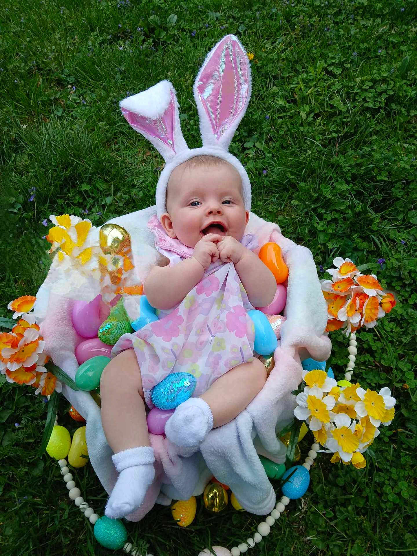 Paisley joined the competition — help win amazing prizes! baby, bunny_ears, easter_eggs, flowers, grass, baby_clothing, smiling, cute, spring, outdoor, greenery, sock, basket, decorations, festive, infant, playful, colorful, happy, holiday