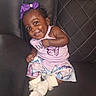 baby, child, smiling, purple_bow, butterfly, dress, socks, couch, leather, quilted, happy, cute, infant, portrait, indoor, person, seated, clothing, face, skin