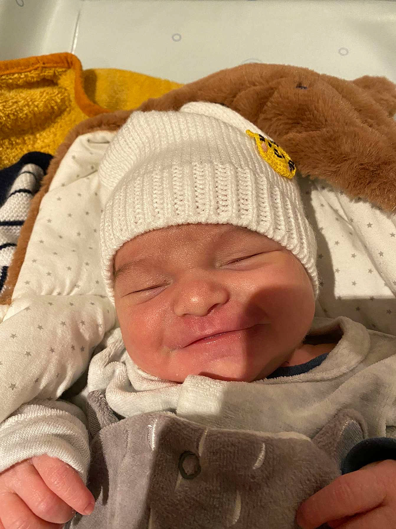 Mélio a rejoint le concours — aidez-le/la à gagner de superbes lots ! baby, baby_products, baby_sleeping, baby_toddler_clothing, cap, cheek, child, comfort, finger, gesture, happy, hat, headgear, headwear, linens, nose, person, skin, smile, thumb