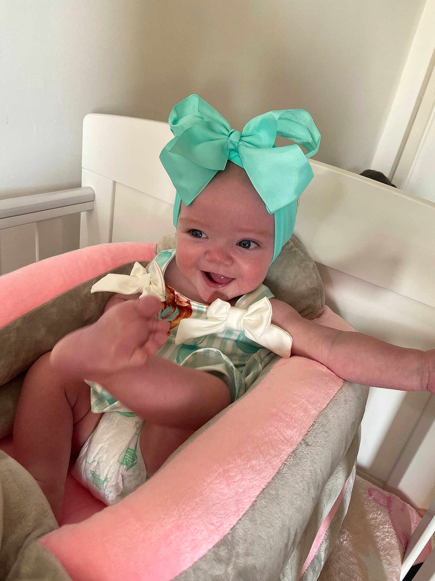 Ivy-Mae joined the competition — help win amazing prizes! baby, child, infant, headband, bow, smile, happy, diaper, seat, cushion, pink, gray, nursery, crib, cute, playful, clothing, indoor, person, face