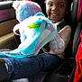Baila joined the competition — help win amazing prizes! child, car_seat, plush_toy, unicorn, backpack, smiling, portrait, autumn, car_interior, seatbelt, jeans, black_hair, window, colorful, toy, happy, person, casual_clothing, indoor, vehicle