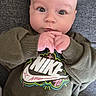 baby, casual, child, clothing, cute, expression, eyes, fabric, face, hair, hands, indoor, infant, nike, person, portrait, sitting, sweatshirt, texture, young