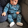 baby, infant, child, person, couch, sofa, clothing, blue, levis, socks, adult, hand, face, head, indoor, seated, soft_fabric, wipes, curious, casual