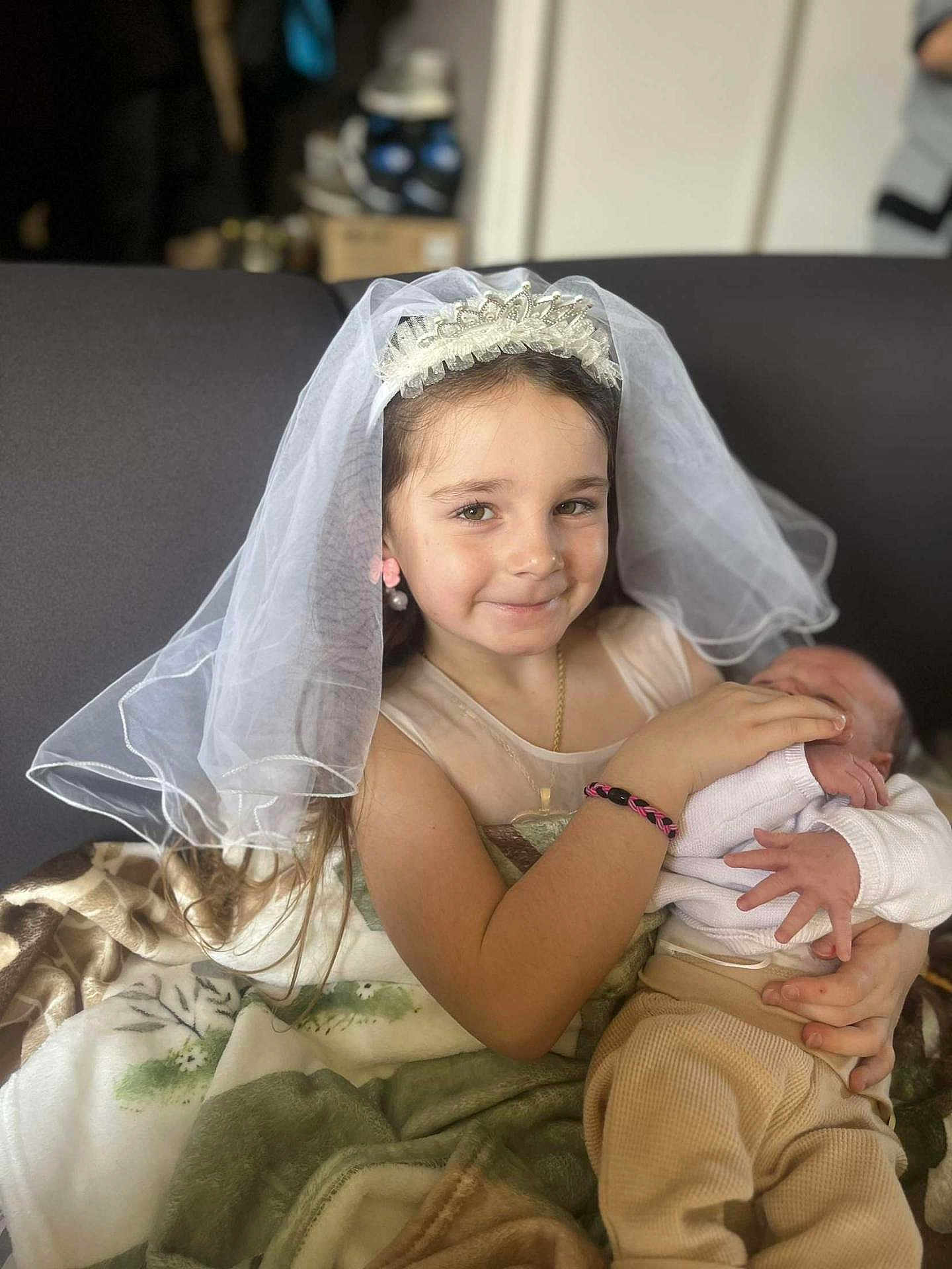 Kaïsya participe au concours pour gagner de l'argent avec cette photo : child, baby, girl, newborn, veil, bracelet, blanket, couch, smile, portrait, indoor, clothing, person, holding, toddler, headwear, jewelry, family, love, tenderness
