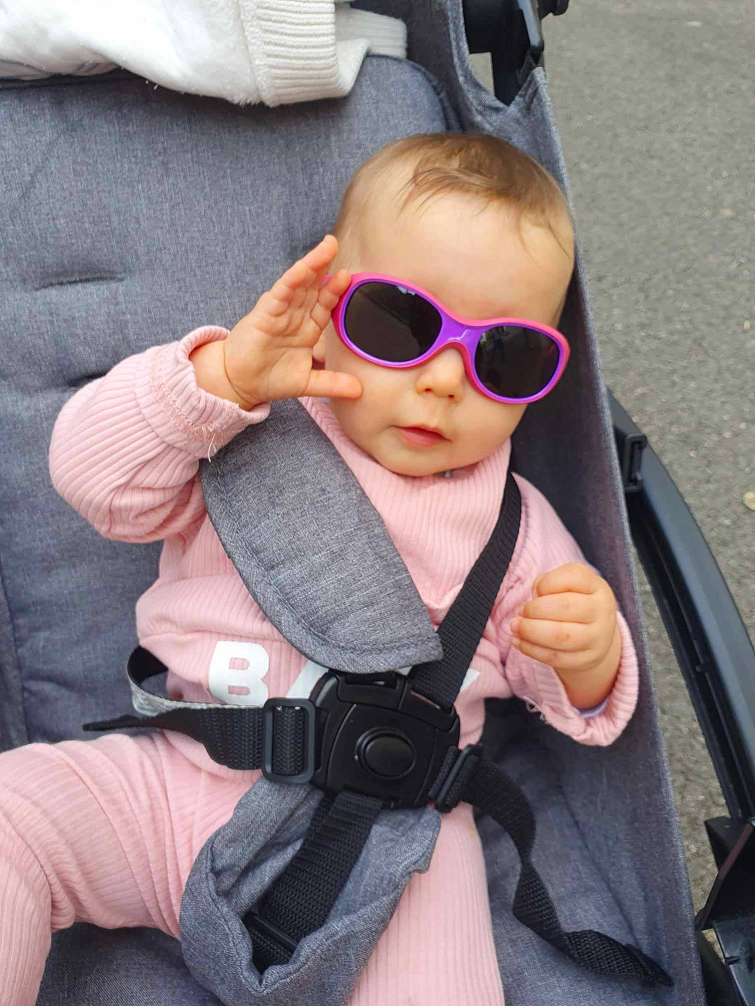Railey participe au concours pour gagner de l'argent avec cette photo : baby_carriage, cheek, cool, eyewear, finger, gesture, glasses, goggles, hairstyle, hand, lip, person, personal_protective_equipment, pink, plant, seat_belt, sleeve, sunglasses, thumb, toddler