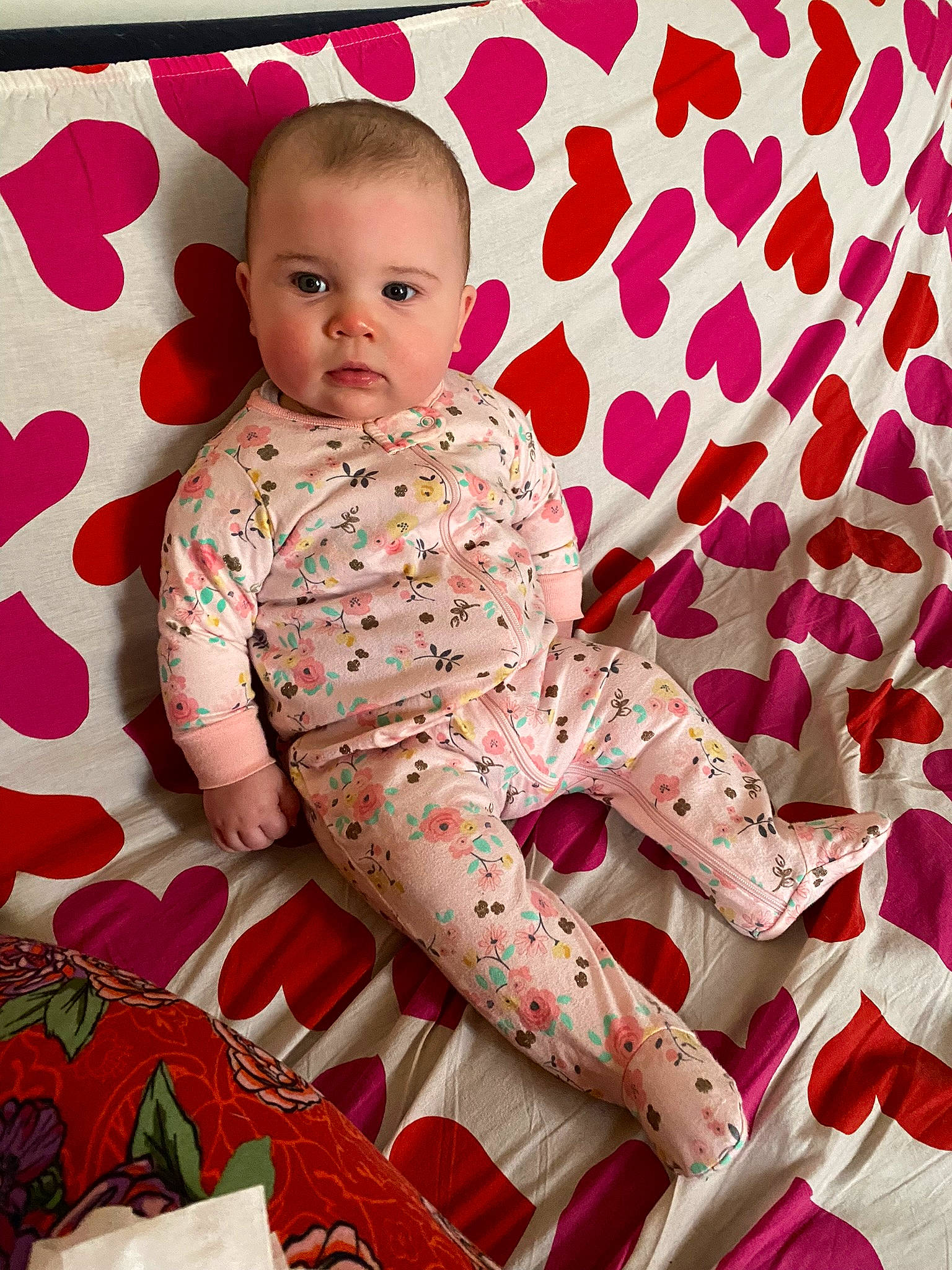 Clarissa is registered to the contest to win money with this photo: baby, baby_toddler_clothing, carmine, child, comfort, face, happy, linens, magenta, pattern, peach, person, pink, product, red, sitting, skin, sleeve, textile, thigh