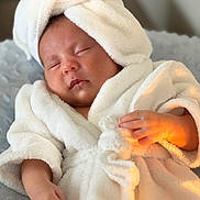 Laura joined the competition — help win amazing prizes! baby, sleeping, bathrobe, towel, soft, fluffy, hand, face, skin, indoors, cozy, comfort, relaxation, child, newborn, portrait, warm_light, cute, infant, resting