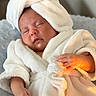 baby, sleeping, bathrobe, towel, soft, fluffy, hand, face, skin, indoors, cozy, comfort, relaxation, child, newborn, portrait, warm_light, cute, infant, resting