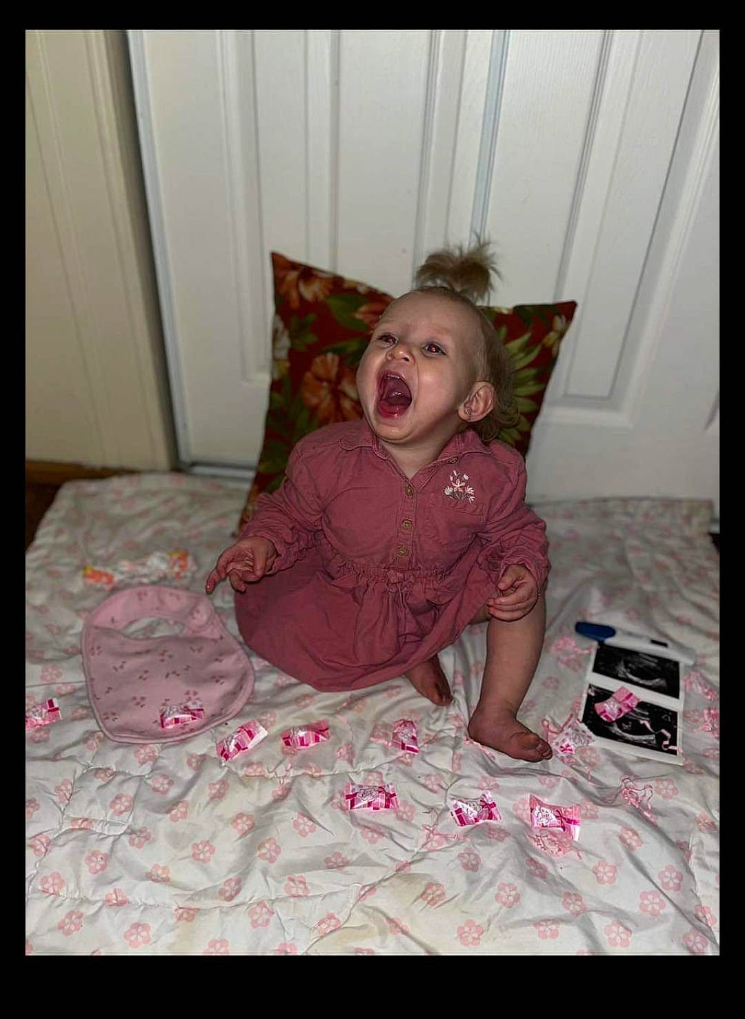 Brylie is registered to the contest to win money with this photo: bed, bedding, bedroom, child, comfort, floor, flooring, fun, human_body, linens, magenta, mouth, pattern, person, pillow, pink, room, sitting, t_shirt, textile