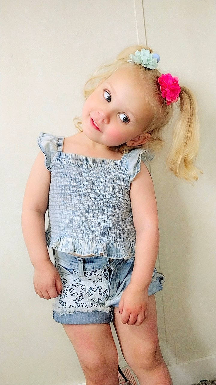 Brylie is registered to the contest to win money with this photo: accessories, baby, blonde, blouse, clothing, costume, dress, face, flower, hair, head, jeans, jewelry, necklace, pants, person, photography, plant, portrait, shorts