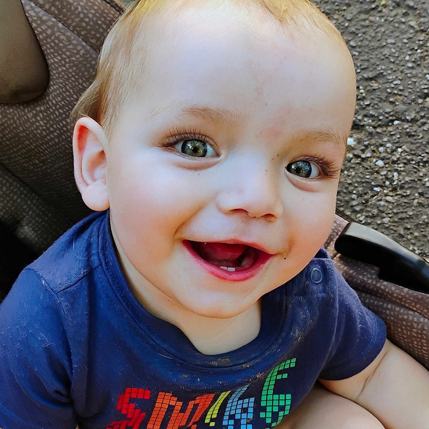 Jayson joined the competition — help win amazing prizes! baby, child, clothing, colorful, cute, expression, face, green_eyes, happy, joyful, outdoor, pavement, portrait, short_hair, sitting, skin, smiling, stroller, toddler, tshirt