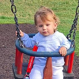 Patrik Conor is registered to the contest to win money with this photo: baby, child, city, electric_blue, eye, face, facial_expression, fun, grass, happy, leisure, outdoor_play_equipment, person, play, playground, recreation, riding_toy, sitting, swing, tire