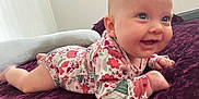 Zoey is registered to the contest to win money with this photo: baby, blanket, bright, child, cozy, cute, earring, face, floral_outfit, happy, head, indoor, infant, lying_down, person, plush, portrait, skin, smile, tummy