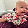 baby, blanket, bright, child, cozy, cute, earring, face, floral_outfit, happy, head, indoor, infant, lying_down, person, plush, portrait, skin, smile, tummy