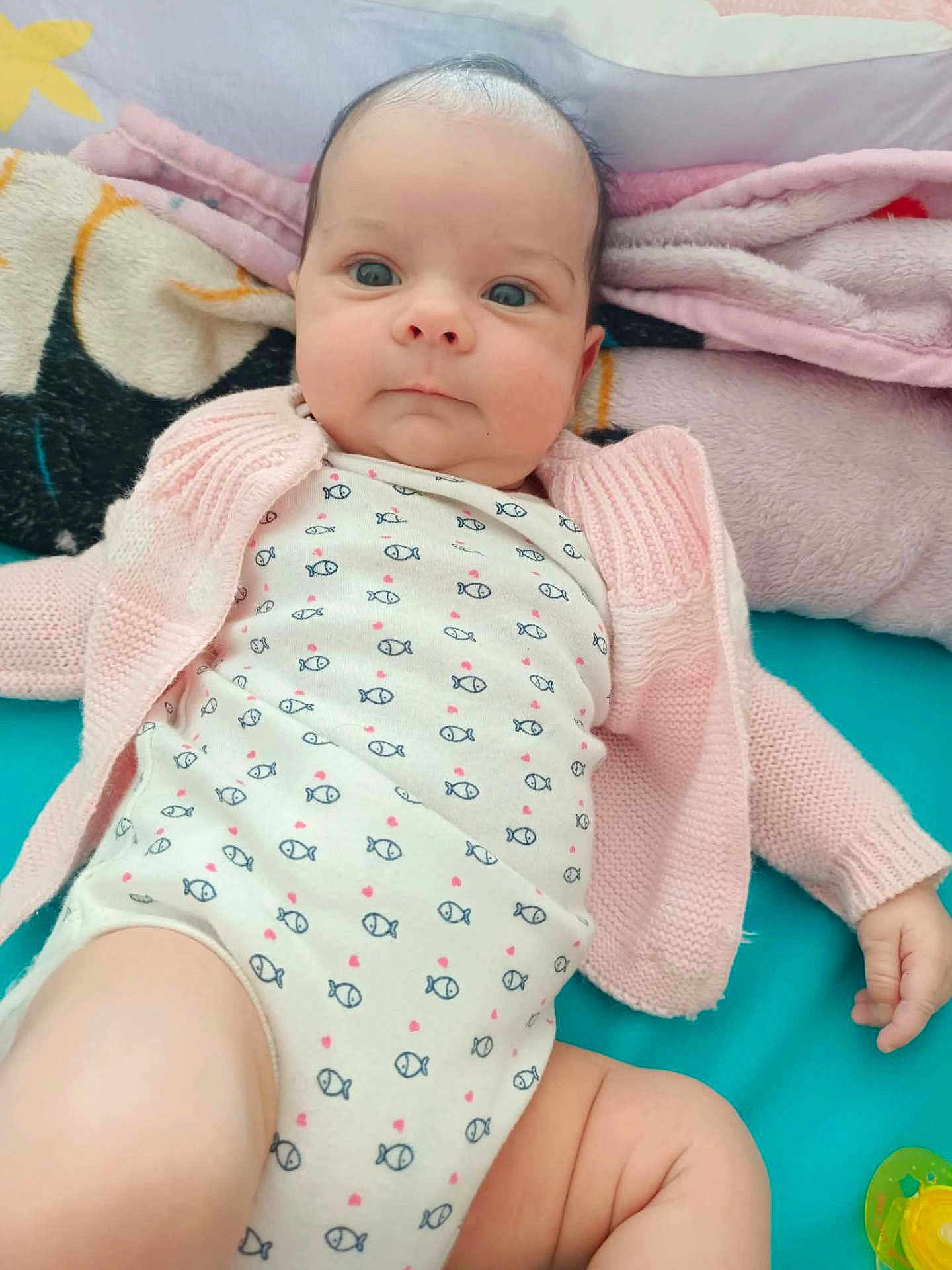 Elmeralda a rejoint le concours — aidez-le/la à gagner de superbes lots ! baby, infant, face, clothing, onesie, cardigan, blanket, lying_down, blue_eyes, hand, leg, soft_toy, pacifier, cute, indoors, child, portrait, expression, skin, fabric