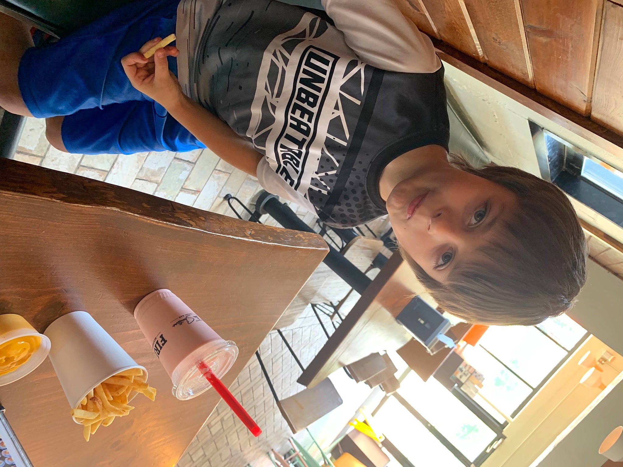 David is registered to the contest to win money with this photo: chair, child, cooking, cuisine, dish, drink, event, finger, food, fun, human, leisure, nail, orange, person, room, t_shirt, table, tableware, thumb