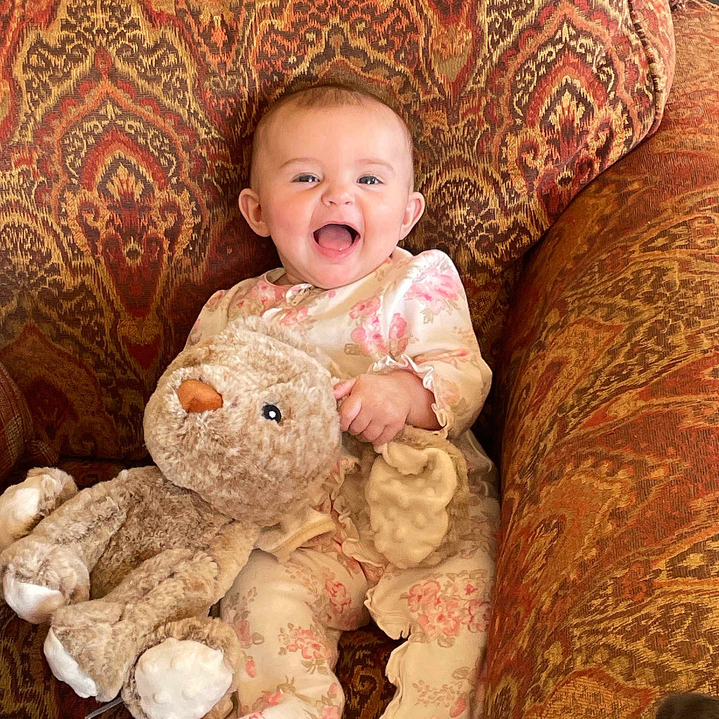 Frankie joined the competition — help win amazing prizes! armchair, baby, baby_clothing, child, comfort, cozy, cute, floral_pajamas, furniture, happy, home, indoor, infant, patterned_fabric, plush_toy, portrait, seated, smiling, soft_toy, stuffed_animal