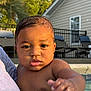 baby, child, wet_skin, water_droplets, arm, hand, person, outdoor, pool, summer, sunlight, house, window, furniture, chair, railing, greenery, face, portrait, closeup