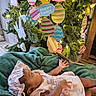 Angel is registered to the contest to win money with this photo: baby, infant, pink_dress, bonnet, blanket, easter, easter_eggs, decorations, holiday, festive, lights, tree, green_blanket, indoors, child, cute, celebration, soft_texture, holiday_decor, person