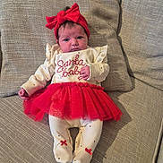 Isla-Rose joined the competition — help win amazing prizes! baby, infant, red_bow, red_tutu, festive_clothing, couch, cushion, white_onesie, footed_pajamas, home_interior, portrait, child, cute, holiday_outfit, indoor, fabric_texture, resting, adorable, small_hands, headband