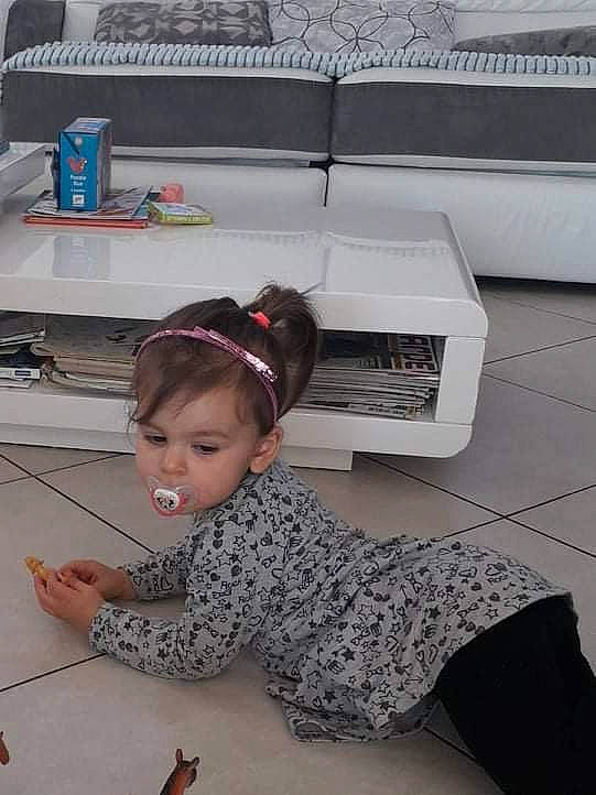 Amy participe au concours pour gagner de l'argent avec cette photo : audio_equipment, chair, child, comfort, desk, electronic_device, eyewear, floor, flooring, gadget, office_equipment, output_device, peripheral, person, room, sitting, sunglasses, t_shirt, technology, toddler