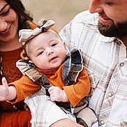 Harlynn is registered to the contest to win money with this photo: baby, child, woman, man, family, smile, love, outdoor, portrait, headband, plaid, clothing, beard, holding, happy, cute, toddler, parent, warm_colors, interaction