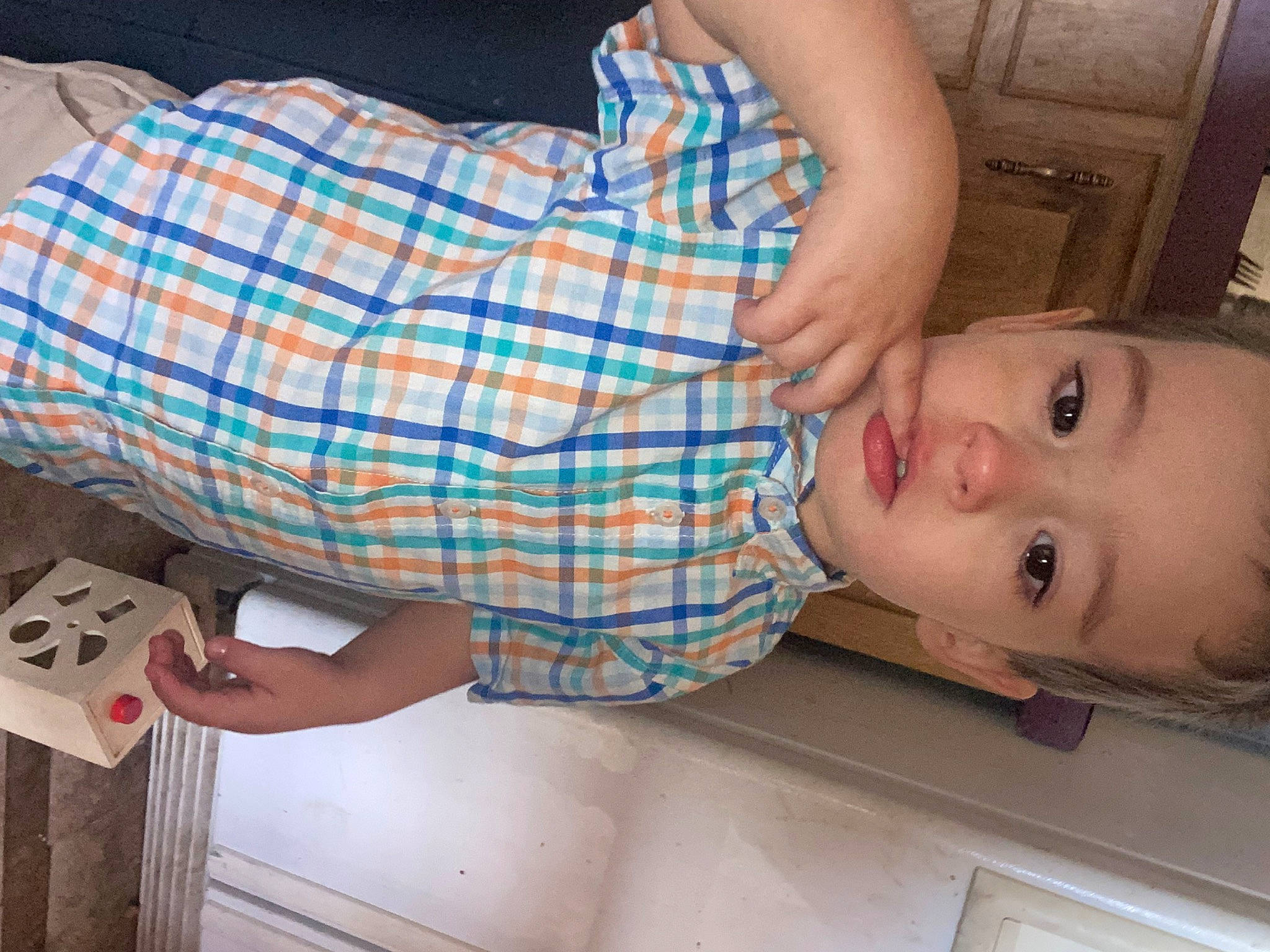 James is registered to the contest to win money with this photo: baby, baby_toddler_clothing, child, comfort, dress, elbow, finger, fun, gesture, hand, joint, leg, nose, person, plaid, sleeve, smile, tartan, textile, toddler