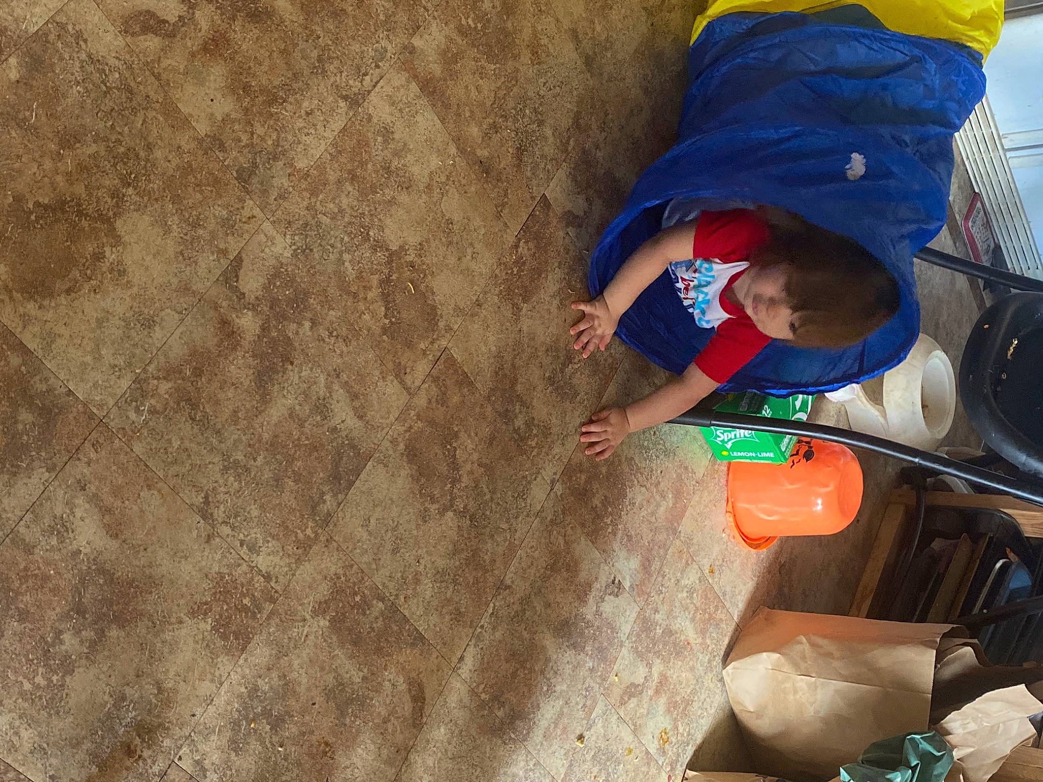 James is registered to the contest to win money with this photo: automotive_tire, child, electric_blue, flooring, fun, hat, landscape, leisure, people_in_nature, person, play, recreation, sand, shadow, sitting, soil, tints_and_shades, tire, toddler, travel