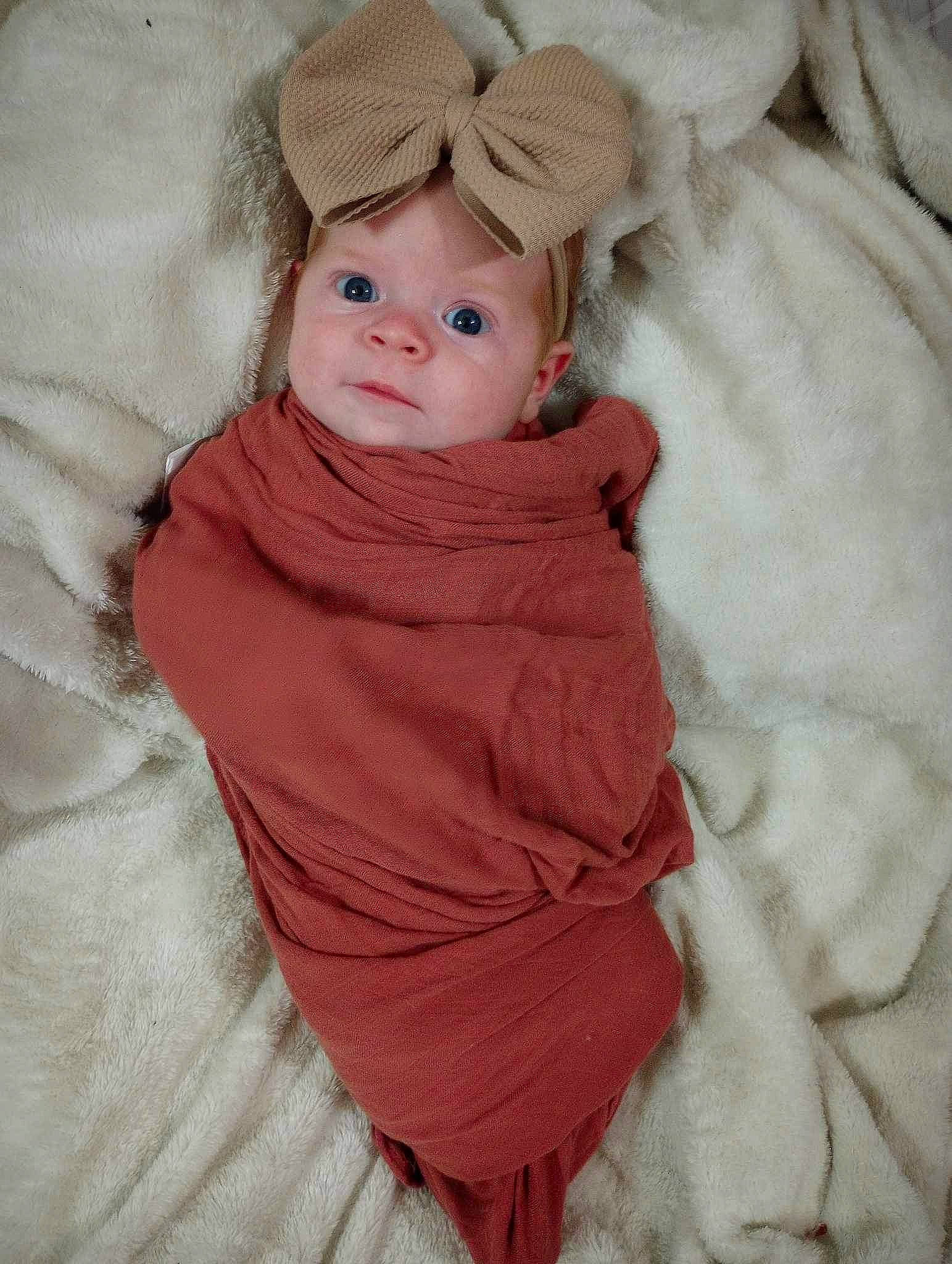 Serenity is registered to the contest to win money with this photo: baby, baby_products, baby_toddler_clothing, beanie, comfort, costume, dress, eye, fashion_accessory, fur, head, headgear, hood, iris, linens, peach, person, sitting, sleeve, toddler
