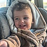 toddler, child, smiling, hooded_robe, car_seat, fuzzy_clothing, happy, indoors, portrait, baby, seatbelt, cozy, young_child, cute, casual, natural_light, person, apparel, expression, car_interior