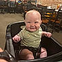 baby, high_chair, smile, indoor, restaurant, child, person, seat, cute, happy, plush, clothing, table, food, people, brick_wall, wood, dining, family, fun