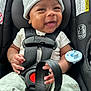 baby, smiling, car_seat, seatbelt, infant, beanie, clothing, pacifier, hands, happy, child, cute, safety, straps, infant_clothing, portrait, closeup, seat, indoors, secure