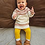 baby, infant, toddler, smiling, happy, couch, cushion, sweater, yellow_leggings, moccasins, shoes, fringe, socks, hands, feet, indoor, portrait, cute, fabric, cozy