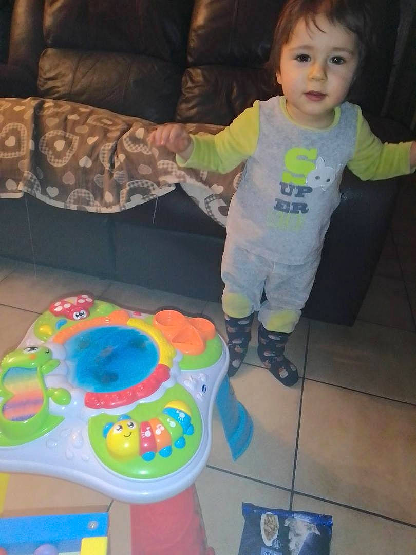 Joey participe au concours pour gagner de l'argent avec cette photo : baby, baby_products, baby_toddler_clothing, cheek, child, comfort, couch, floor, flooring, fun, leisure, person, plastic, play, room, sandal, sleeve, t_shirt, toddler, visual_arts